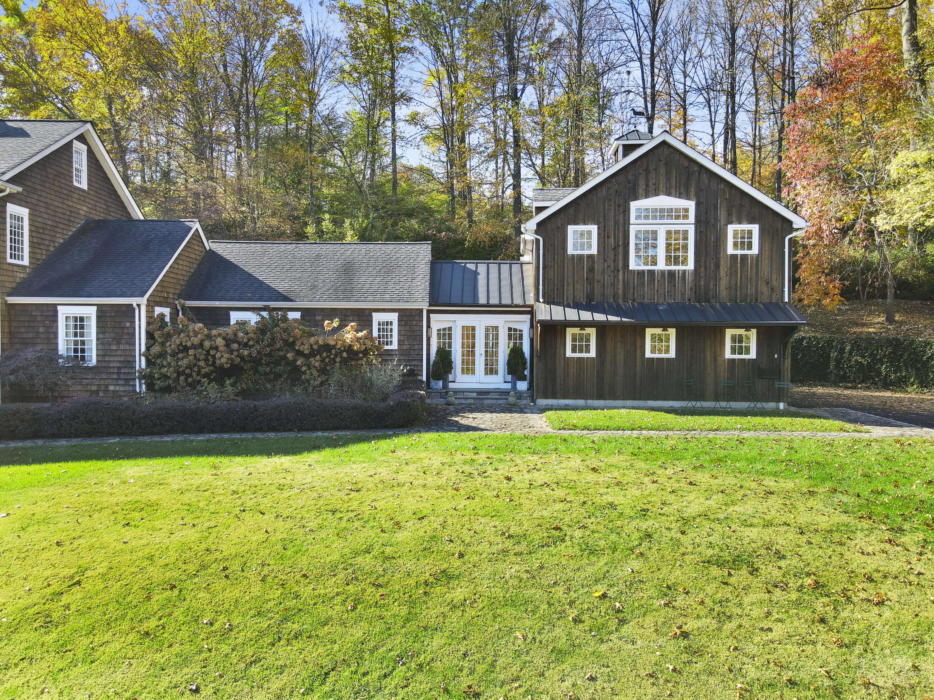 215 Cross Ridge Road New Canaan, CT 06840 - Photo 44 of 50 a front view of a house with a yard and trees