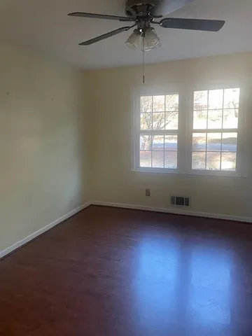 an empty room with a window and a fan