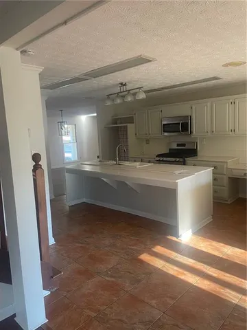 a kitchen with granite countertop a sink and a stove top oven