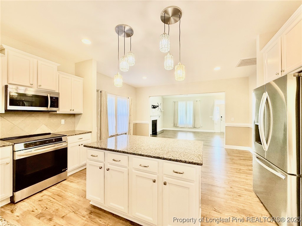 107 Judiciary Court Cameron, NC 28326 - Photo 6 of 49 a kitchen with stainless steel appliances granite countertop a stove a sink and a refrigerator