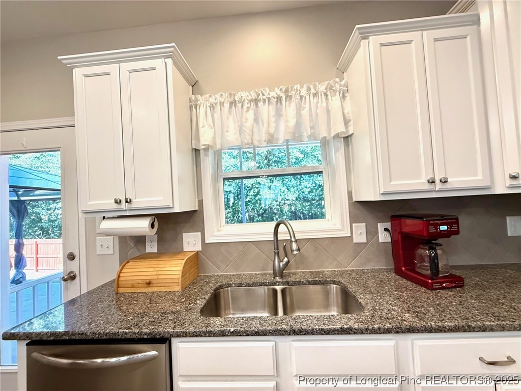 107 Judiciary Court Cameron, NC 28326 - Photo 10 of 49 a kitchen with granite countertop a sink a window and cabinets