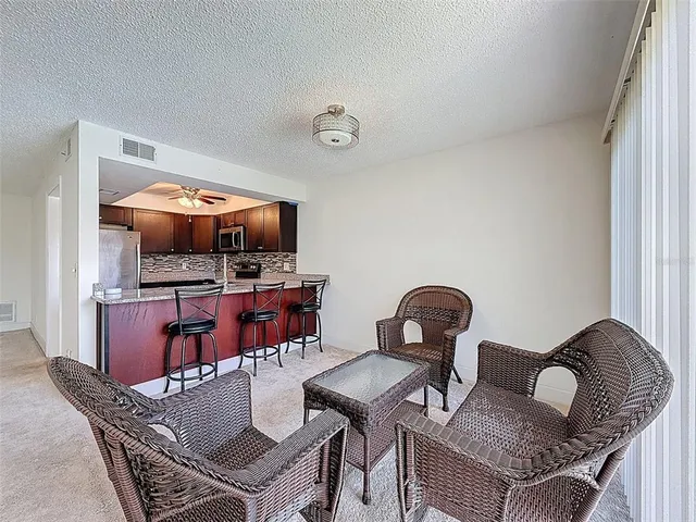 a living room with furniture and kitchen view