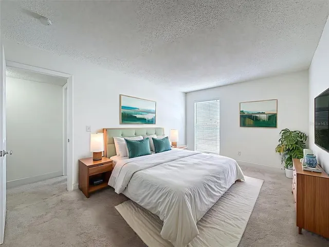 a bedroom with a bed lamp and a potted plant
