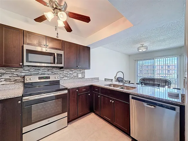a kitchen with stainless steel appliances granite countertop a sink and stove top oven