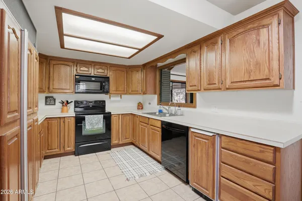 a kitchen with kitchen island granite countertop a stove sink and cabinets