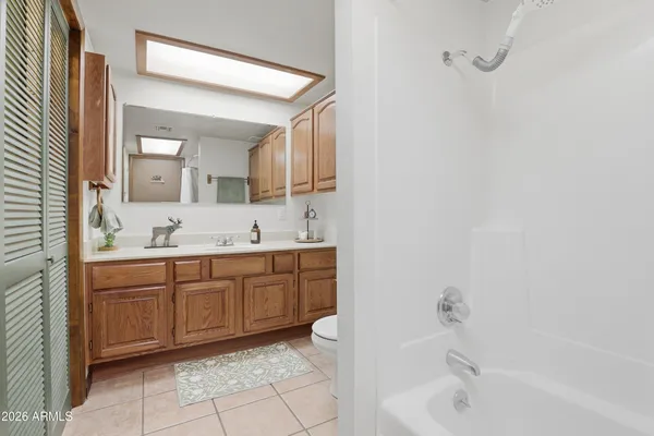 a spacious bathroom with a tub sink and mirror