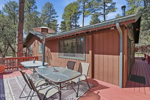 a view of a patio with table and chairs with wooden floor and fence