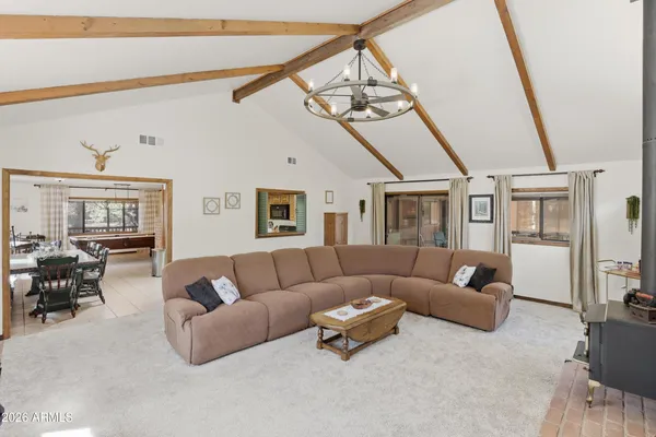 a living room with furniture a chandelier and a dining table