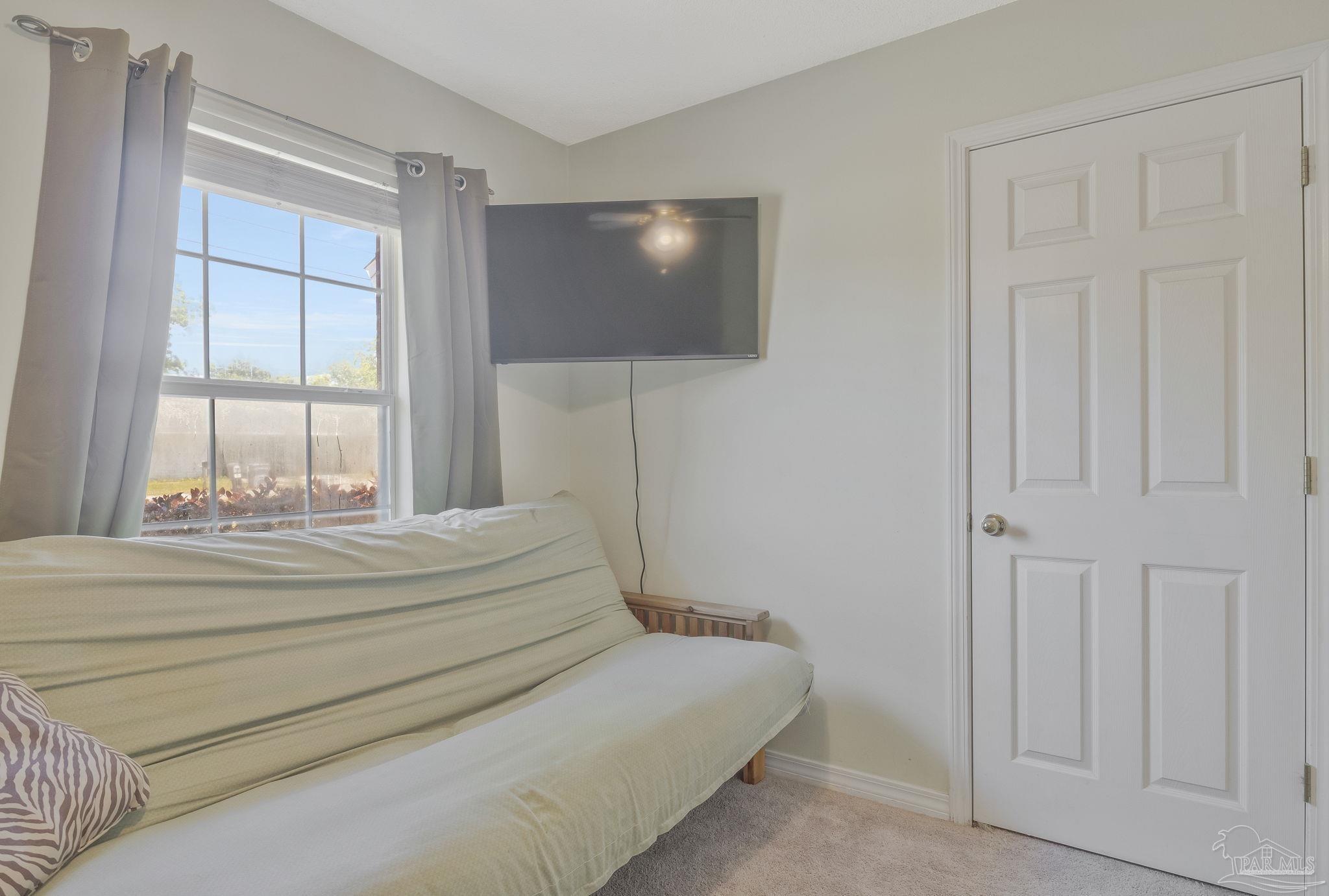 5539 Windrun Place Pace, FL 32571 - Photo 24 of 62 a spacious bedroom with a bed and a chandelier