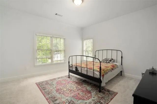 a bed sitting in a bedroom next to a window