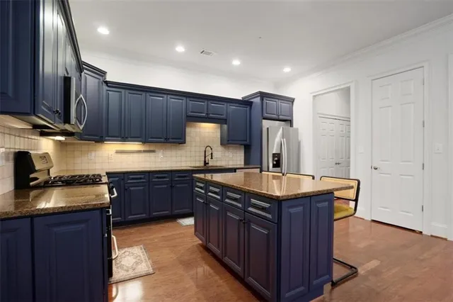a kitchen with stainless steel appliances granite countertop wooden cabinets a sink and a stove