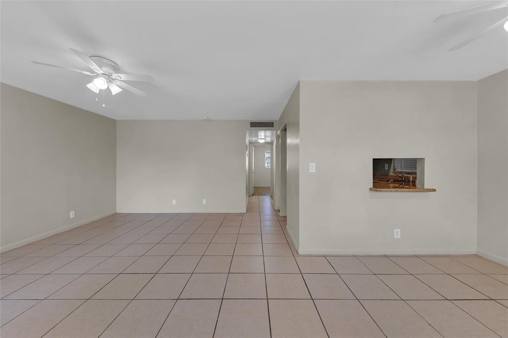 2201 Northeast 36th Street, Unit 205 Lighthouse Point, FL 33064 - Photo 2 of 40 a view of an empty room with window and chandelier fan