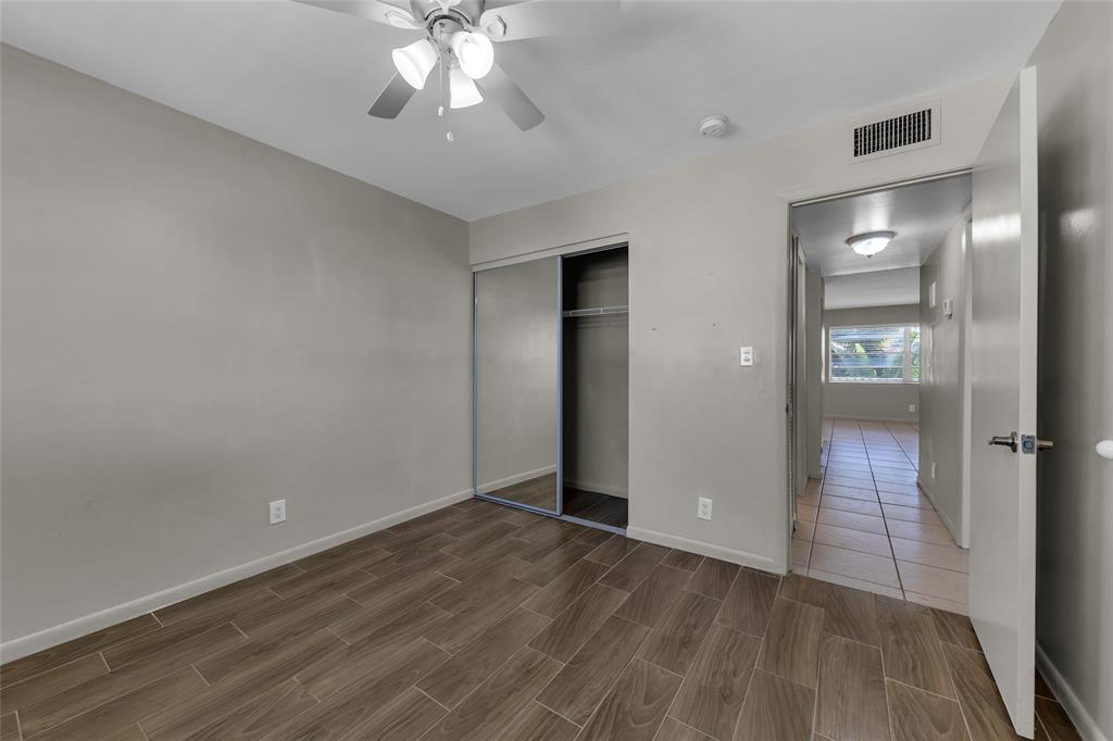 2201 Northeast 36th Street, Unit 205 Lighthouse Point, FL 33064 - Photo 23 of 40 wooden floor in an empty room with a mirror