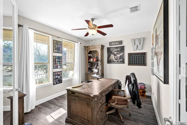 a view of a workspace with furniture and a window