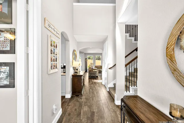 a view of a hallway with wooden floor and staircase