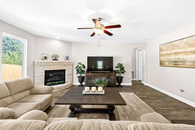 a living room with furniture a flat screen tv and a fireplace