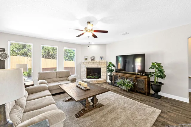 a living room with furniture a flat screen tv and a fireplace