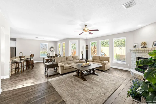a living room with lots of furniture wooden floor and window