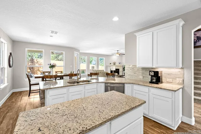 a kitchen with stainless steel appliances granite countertop sink stove top oven and cabinets