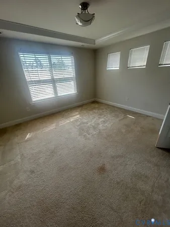 an empty room with windows and ceiling fan