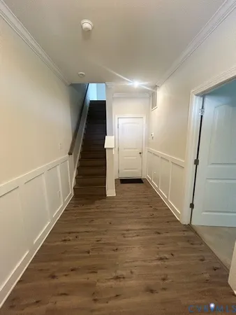 a view of a hallway with wooden floor and staircase