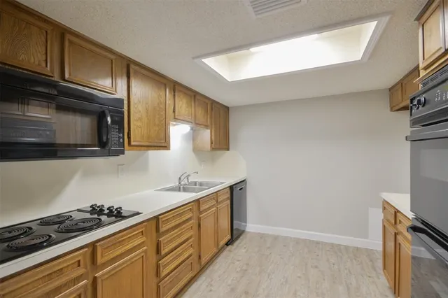 a kitchen with stainless steel appliances a sink a stove and cabinets