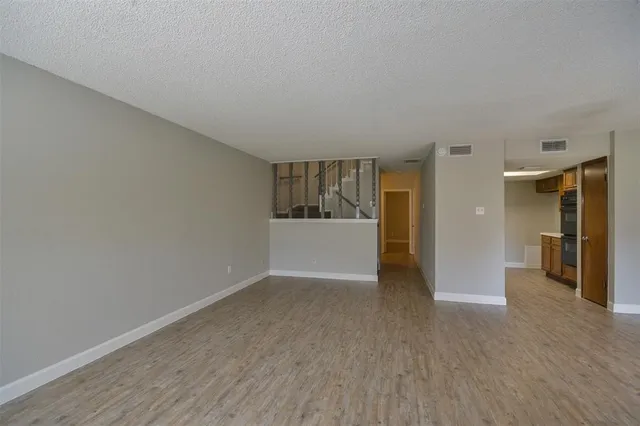 a view of a big room with wooden floor and windows