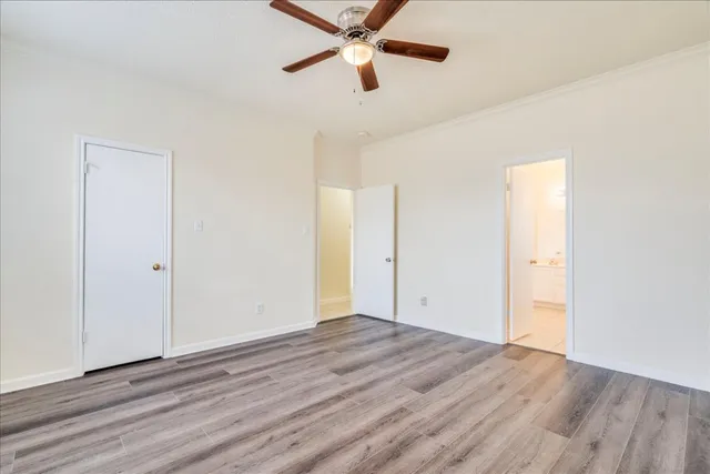 an empty room with wooden floor a ceiling fan and closet