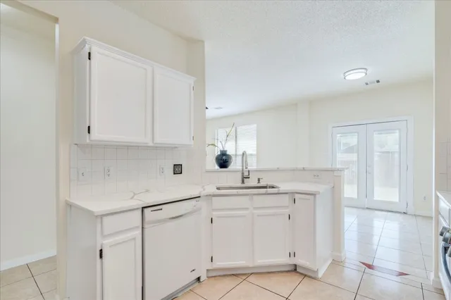 a kitchen with white cabinets appliances and a sink