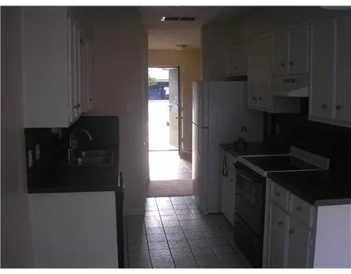 a kitchen with a refrigerator a stove and cabinets