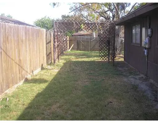 a view of a yard with wooden fence
