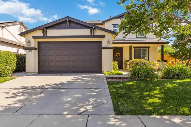 a front view of a house with a yard and potted plants