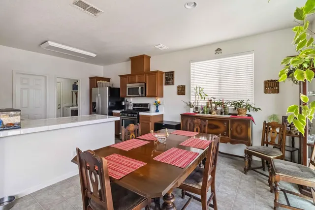 a dining room filled chandelier and kitchen view