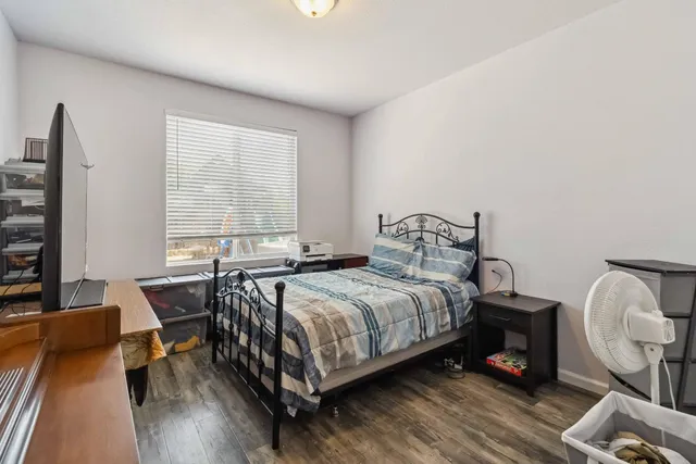 a bedroom with a bed a table and a flat screen tv