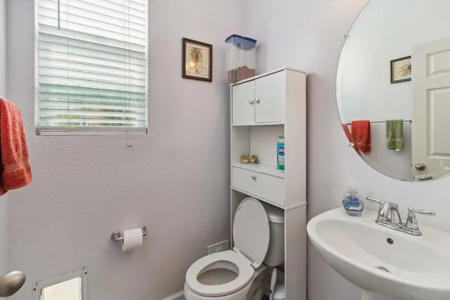 a bathroom with a toilet sink and mirror