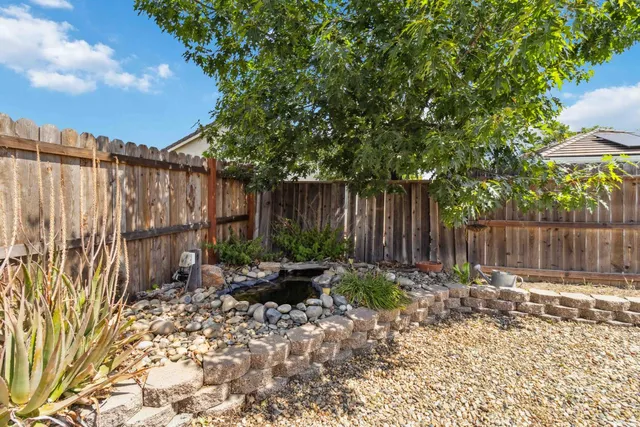a view of a house with entertaining space and a wooden fence