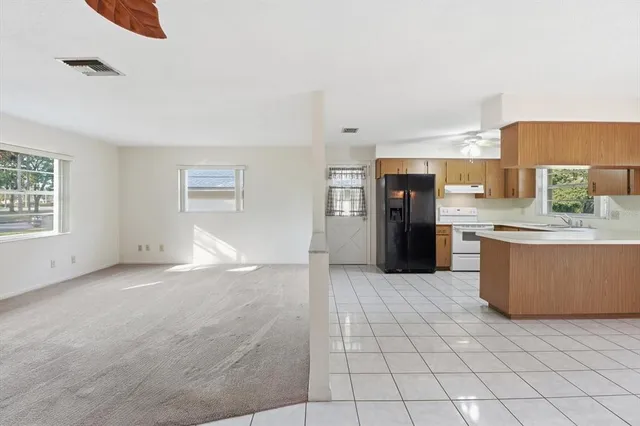 a view of a kitchen with a sink and an empty room