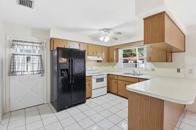 a kitchen with stainless steel appliances granite countertop a refrigerator and a sink