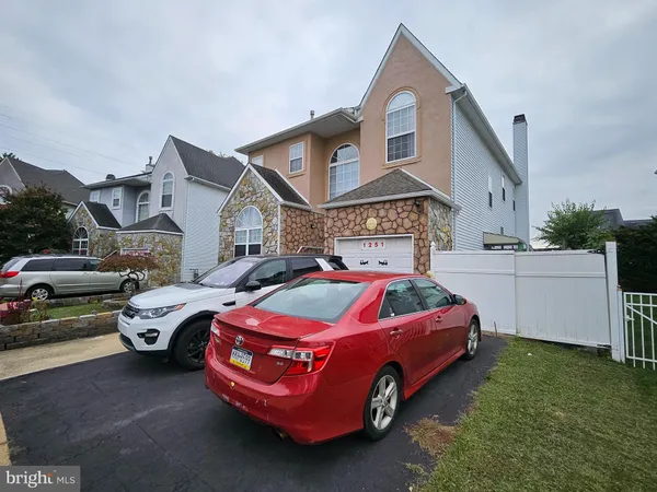 a front view of a house with cars parked