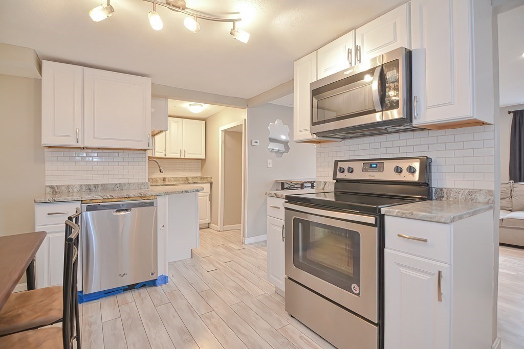 8 Maple Avenue Danvers, MA 01923 - Photo 9 of 42 a kitchen with granite countertop cabinets stainless steel appliances and wooden floor