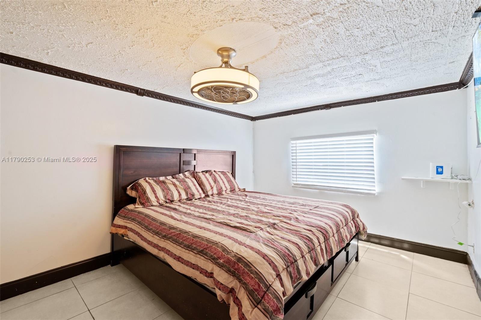 5731 Simms Street Hollywood, FL 33021 - Photo 15 of 33 a bedroom with a bed and a chandelier