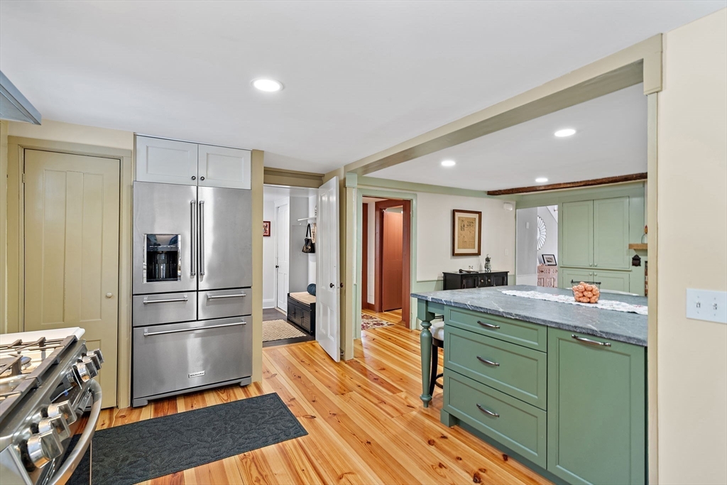 228 Main Street Groton, MA 01450 - Photo 18 of 33 a kitchen with stainless steel appliances kitchen island granite countertop a refrigerator and a stove top oven