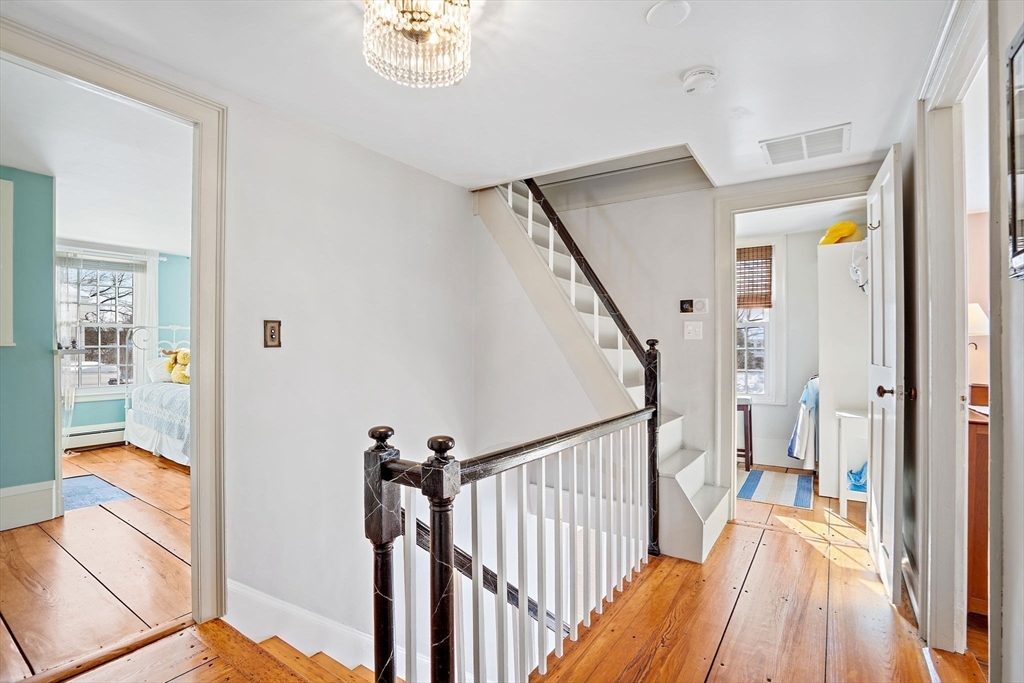 228 Main Street Groton, MA 01450 - Photo 19 of 33 a view of a hallway with wooden floor and staircase