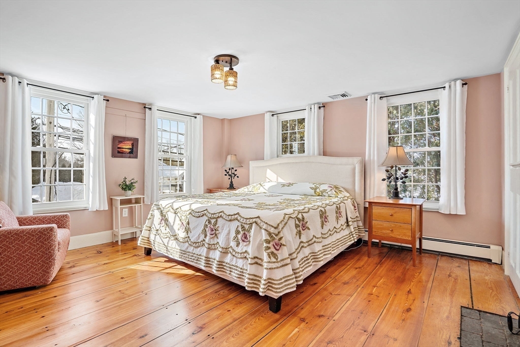 228 Main Street Groton, MA 01450 - Photo 22 of 33 a spacious bedroom with a bed and wooden floor