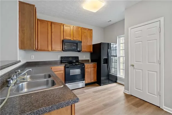 a kitchen with granite countertop a refrigerator and a sink