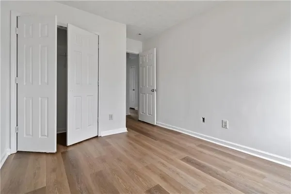 a view of an empty room with wooden floor