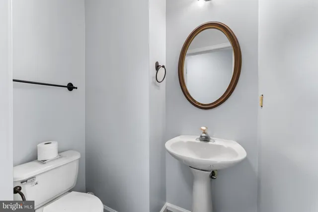 a bathroom with a toilet a sink and a mirror