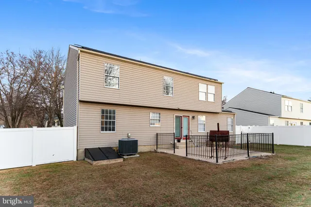 a backyard of a house with table and sofas