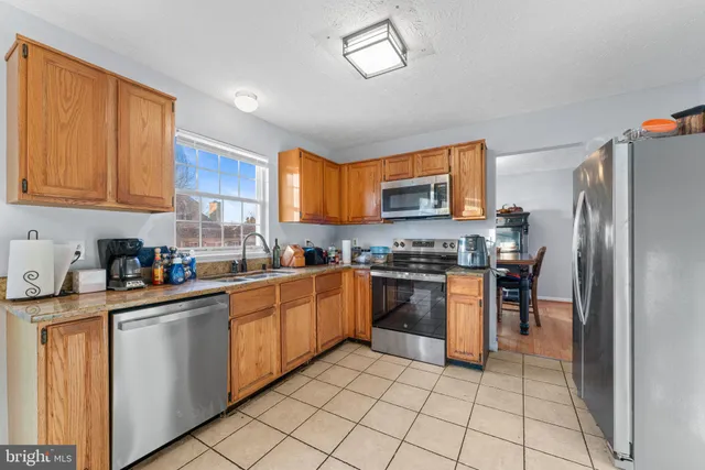 a kitchen with stainless steel appliances granite countertop a refrigerator stove top oven and sink
