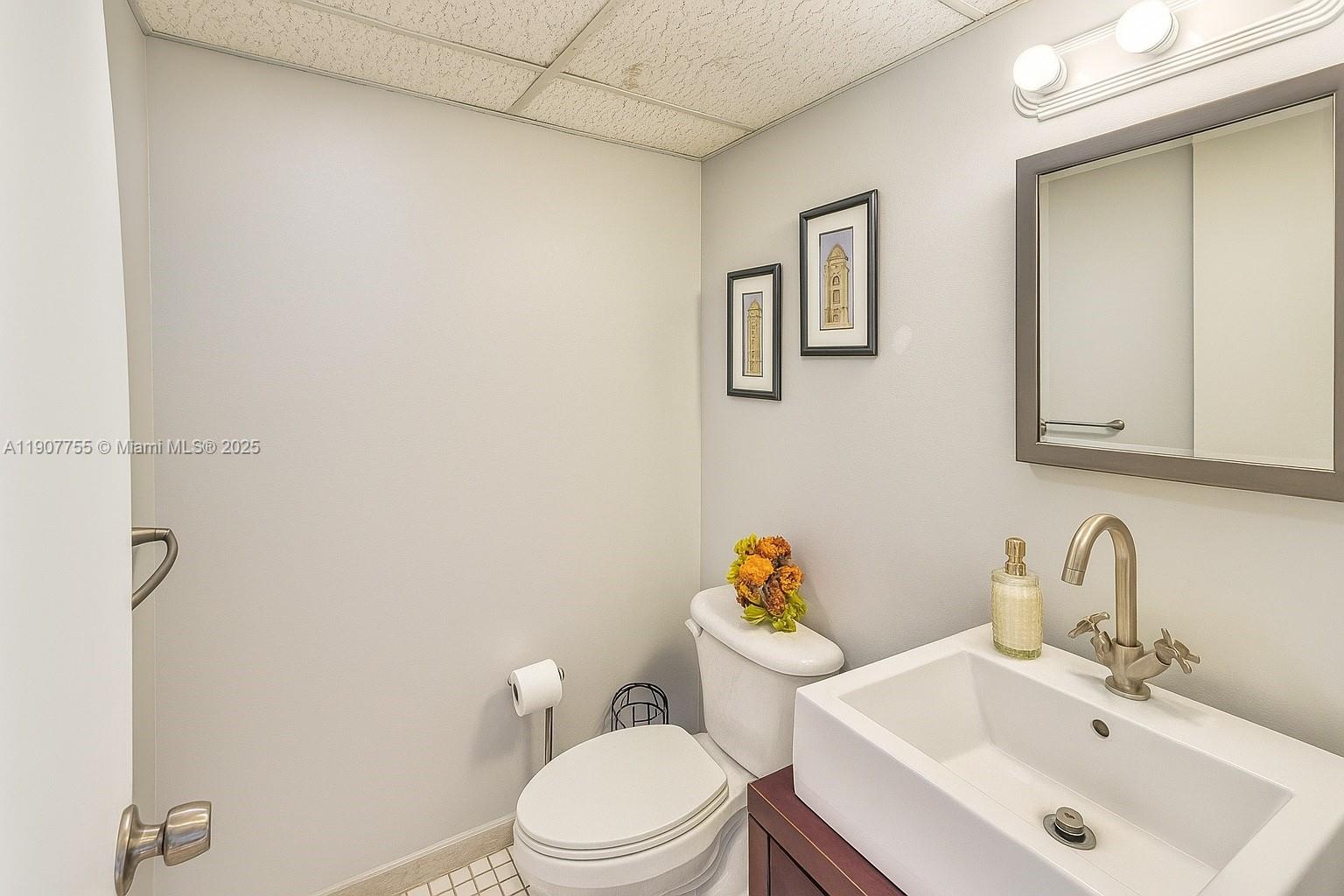 200 172nd Street, Unit 201 Sunny Isles Beach, FL 33160 - Photo 4 of 12 a white toilet sitting next to a bathroom sink